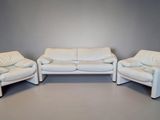 three white leather couches and two chairs in a room