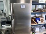 a stainless steel refrigerator in the middle of a kitchen