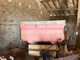 a pink boat in the middle of a barn filled with animals