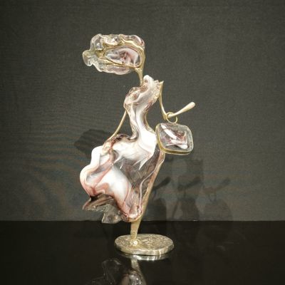 une figurine en verre représentant une femme assise sur une chaise