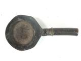 an old frying pan with a handle on a white surface