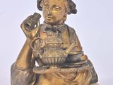 une statue représentant une femme tenant un bol de nourriture