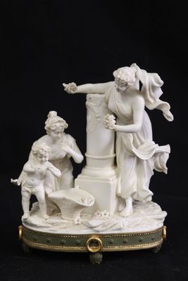 figurine ancienne d'un homme et d'une femme sur un piédestal