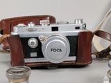 a small camera with a leather case on a table
