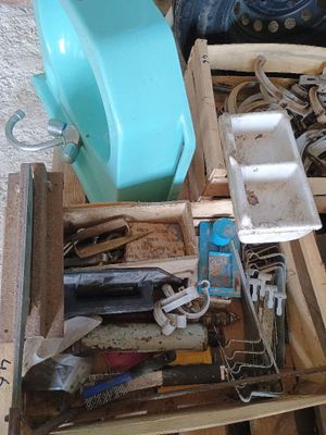 une caisse en bois remplie d'outils divers, posée par terre