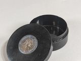 un petit récipient en métal contenant une pièce de monnaie
