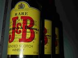 trois bouteilles de bière posées sur une étagère dans une pièce