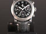 a close up of a watch on a black stand on a black surface