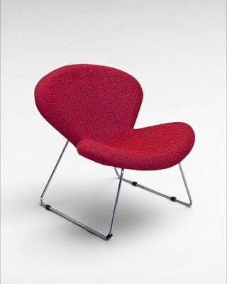 the red chair is sitting on a metal frame on a white background