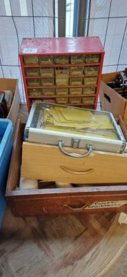 Plusieurs cartons contenant des objets divers sont posés sur un plancher en bois.