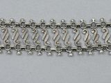 a close up of a silver chain bracelet on a white surface