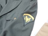 a suit jacket with a gold eagle patch on the lapel