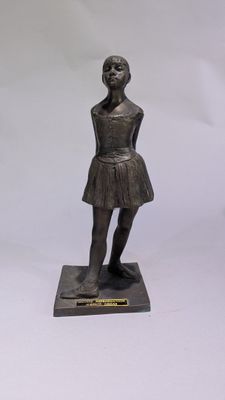 statue en bronze représentant une jeune fille en robe, posée sur un socle en marbre