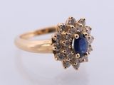 a close up of a gold ring with a blue sapphire and white diamonds