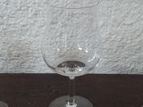 three wine glasses sitting on a table next to each other