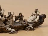 a figurine of a group of people sitting on a boat