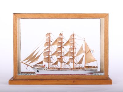 wooden model of a ship in a glass case on a white background