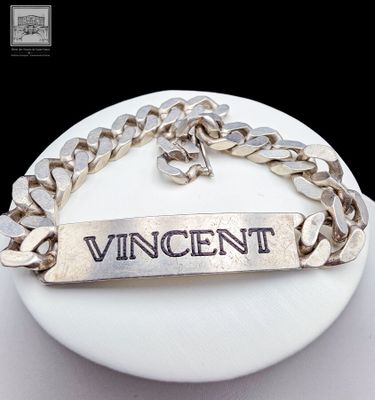 un bracelet en argent sur lequel est gravé le mot « Vincent »