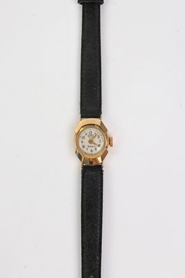 gros plan d'une montre sur une surface blanche avec un bracelet noir