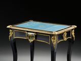 une petite table avec un plateau en verre et des bordures dorées