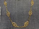 un collier plaqué or posé sur un morceau de tissu