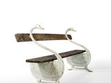 two swans that are sitting on a bench