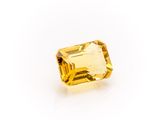 a yellow sapphire stone on a white background