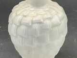 a white vase sitting on a table with a black background