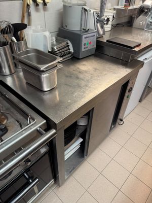 stainless steel counter top in a commercial kitchen with pots and pans on it