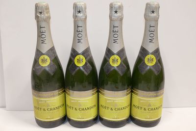 three bottles of moet champagne are lined up on a table
