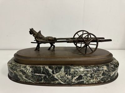 statue représentant un cheval tirant une charrette, posée sur un socle en marbre