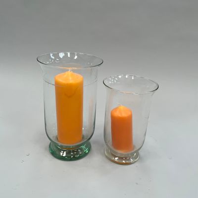 deux vases en verre contenant des bougies, posés sur une table