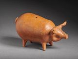 une petite figurine de cochon marron posée sur une table