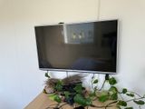 une télévision à écran plat posée sur une table en bois
