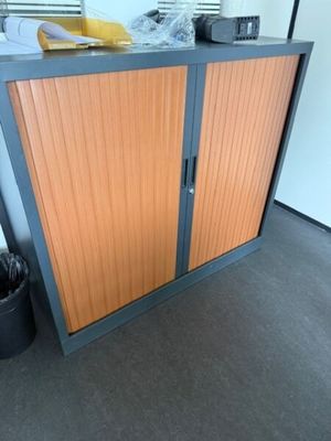 une armoire avec une porte et une poubelle à côté