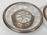 two glass plates with silver rims on a white table