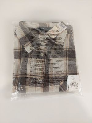 un gros plan d'une chemise emballée dans du plastique posée sur une surface blanche