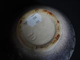 a close up of a white vase with a tag on it
