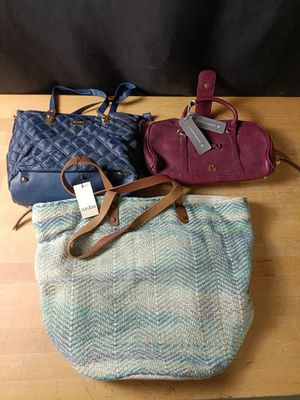 deux porte-monnaie et un sac à main posés sur une table, avec une étiquette de prix