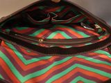 a person holding a purse with a multicolored pattern on it