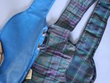 a blue and green plaid bag with a guitar case on it