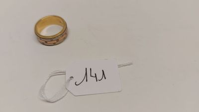 une bague et une étiquette sur une surface blanche