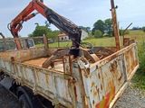 a rusted truck with a crane on the back of it