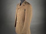 a brown coat on a mannequin stand against a gray background