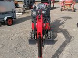 a red tractor that is parked in the dirt