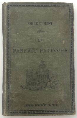 un vieux livre posé sur une table à côté d'un mur blanc