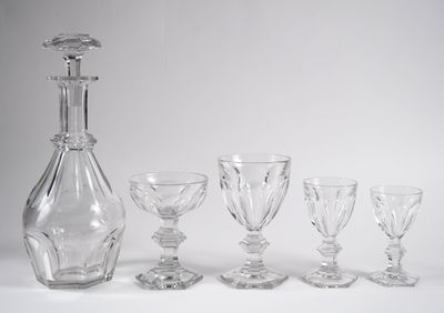 cinq verres à vin et une carafe posés sur une table
