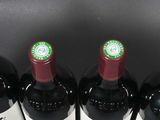 six bottles of wine are lined up in a row on a table