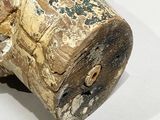 a close up of a wooden object on a white surface