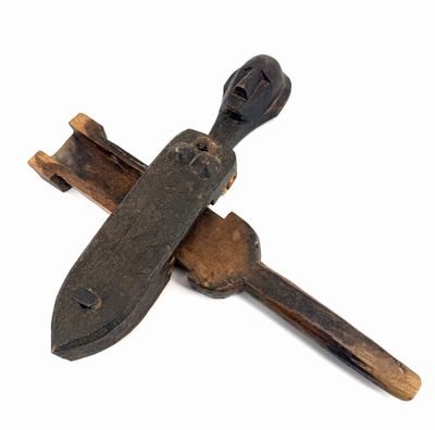 a wooden cross with a knife on it on a white surface